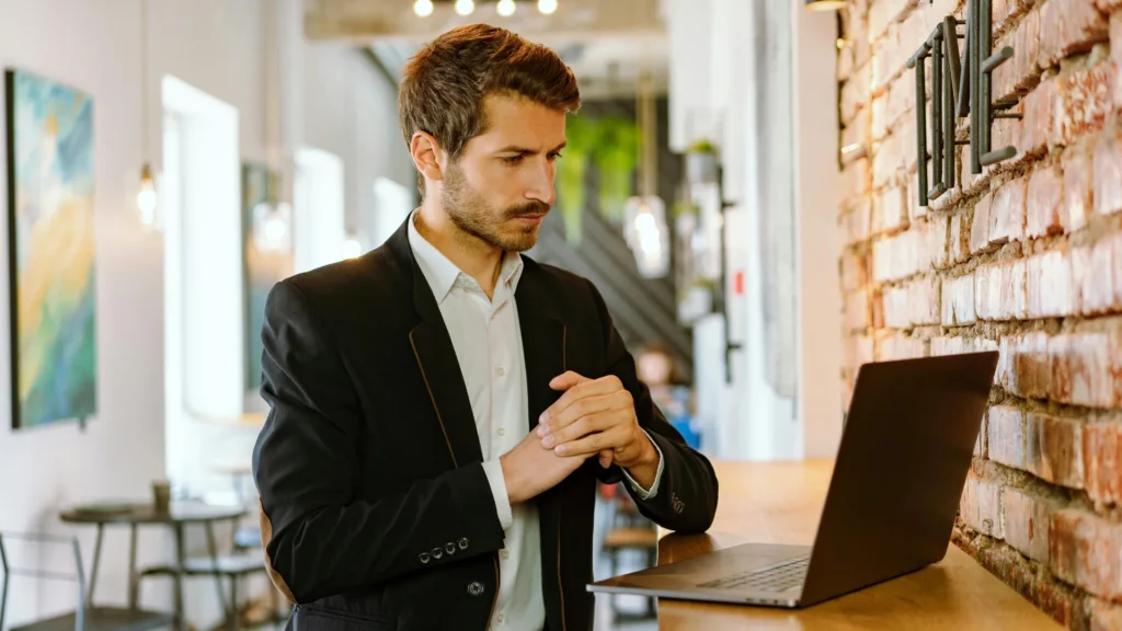 Un apporteur d'affaires autoentrepreneur seul devant son pc qui réfléchi et travaille