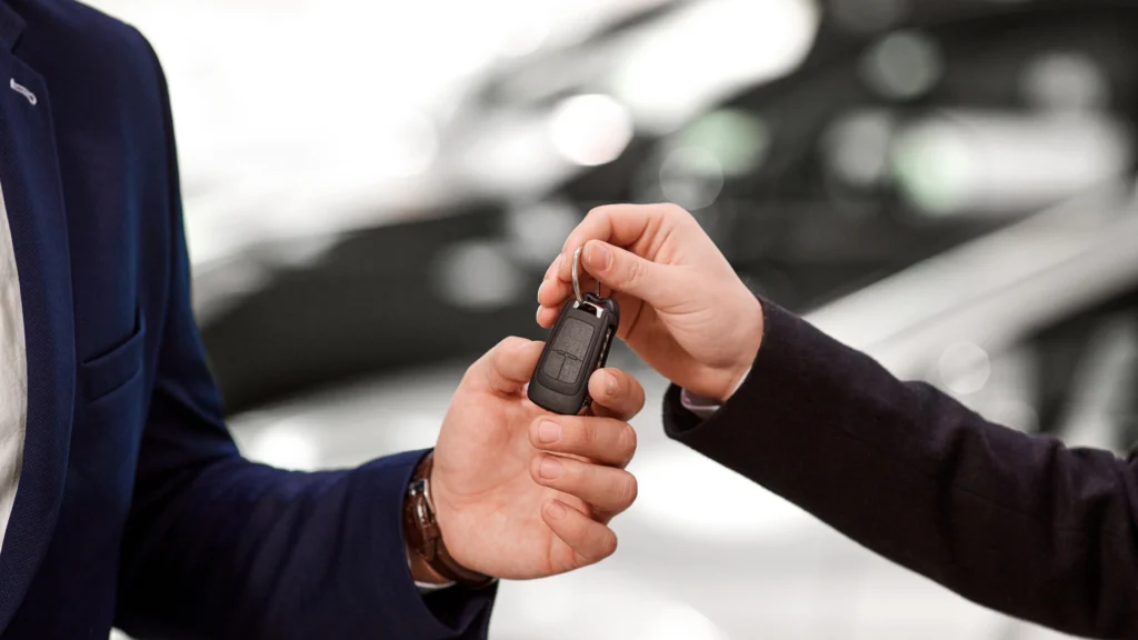 Apporteur d’affaires en automobile concluant une vente de voiture avec remise de clés au client